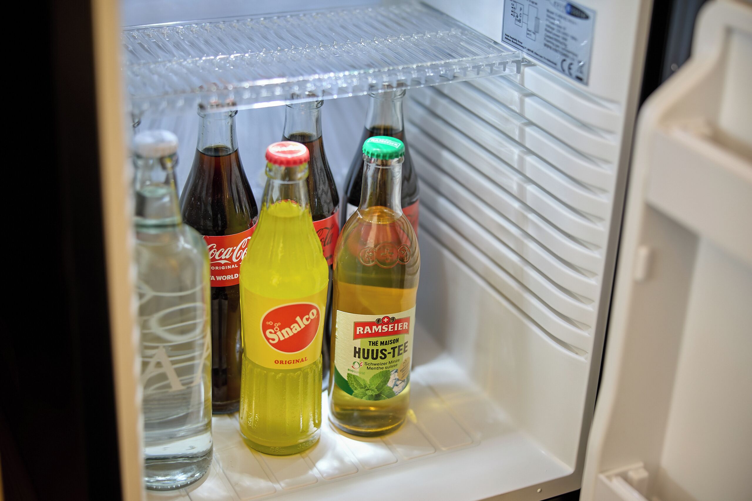 Un réfrigérateur avec des étagères contenant des bouteilles de boissons.
