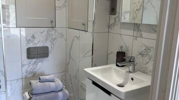 A modern bathroom with a toilet, sink, and mirror.
