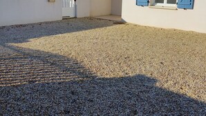 A modern building with a tiled roof, a gravel driveway, and a white exterior wall. - 2 Bedroom Private vacation home in Longeville sur mer (Longeville sur mer)