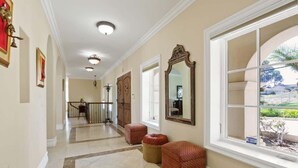 A hallway with a tiled floor, a large mirror, and a window with a view of the outside. - City View Rancho Palos Verdes Home (Rancho Palos Verdes)