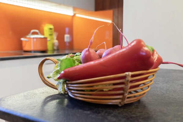 Una cesta de mimbre con verduras sobre una encimera de cocina.