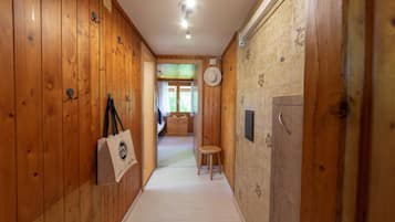 Un couloir en bois avec un lit, une petite table et une chaise.
