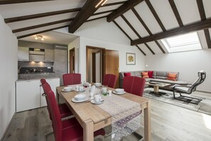 Enjoy meals in the dining area with a wooden table and comfortable seating for four.