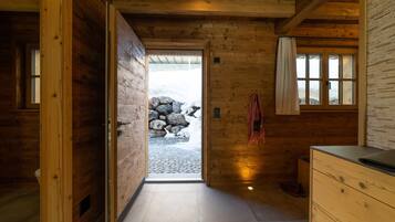 A wooden interior with a stone wall, a wooden door, and a window.