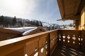 A wooden balcony with a view of a snowy mountain landscape.