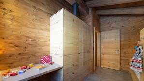 Un intérieur en bois avec un placard intégré, une petite table sur laquelle se trouvent divers objets, et une porte qui donne sur une autre pièce.