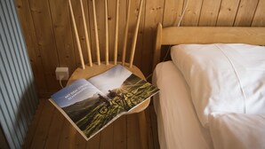 Une chaise en bois, avec un magazine à la couverture représentant un paysage de montagne et un vélo.