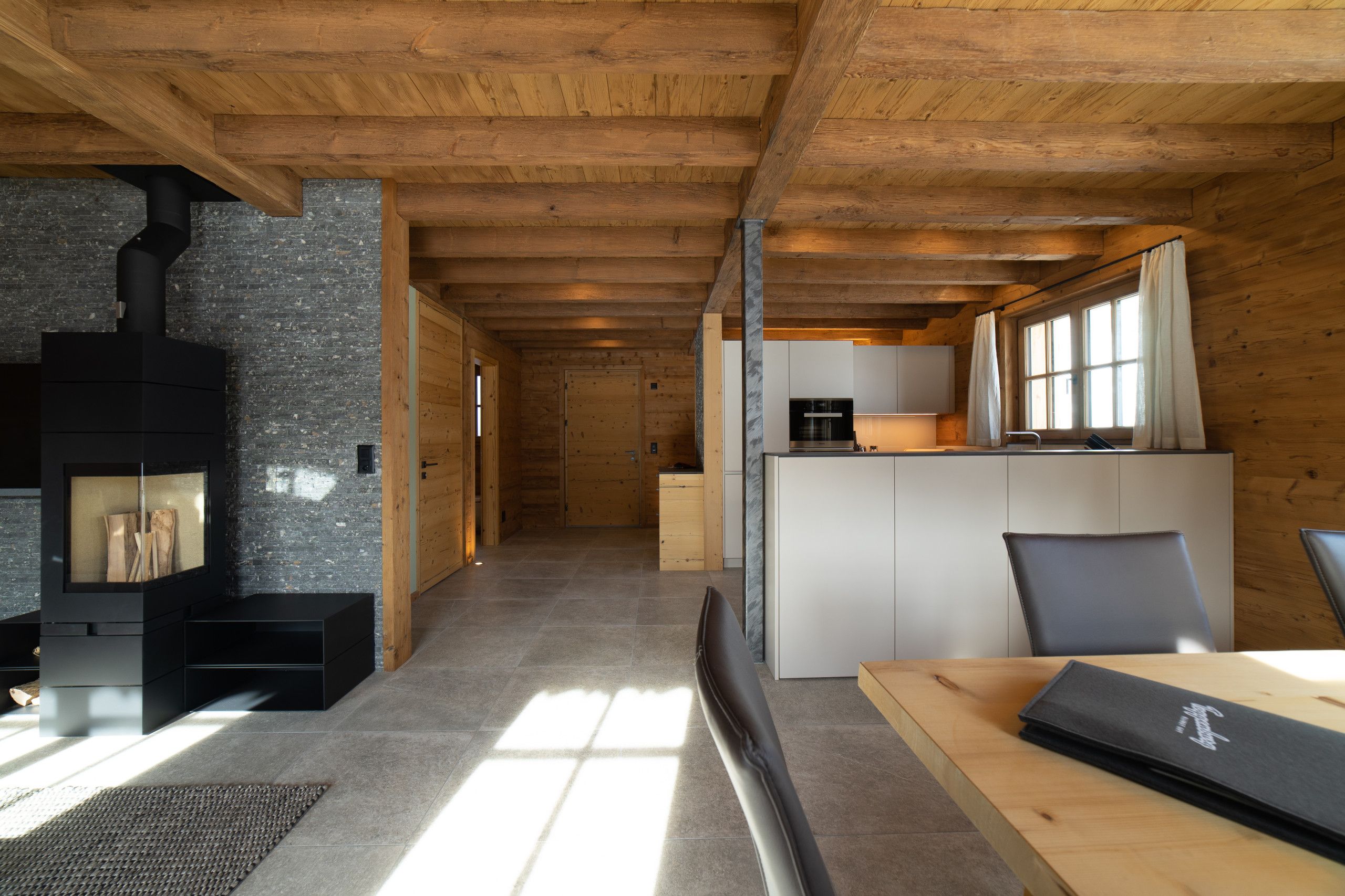 A modern interior with a fireplace, a kitchen area, and a dining space.