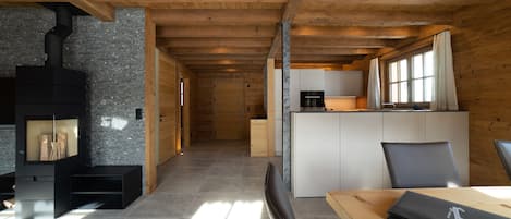 Un interior moderno con chimenea, una zona de cocina y un comedor.