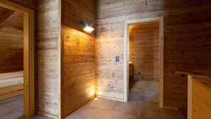 A wooden interior with a tiled floor, a wall-mounted light fixture, and a door leading to another room. - Schibenstoll 4-room chalet near the mountain railways (Wildhaus)