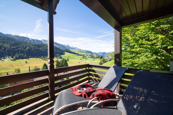 A balcony with a view of a mountainous landscape.