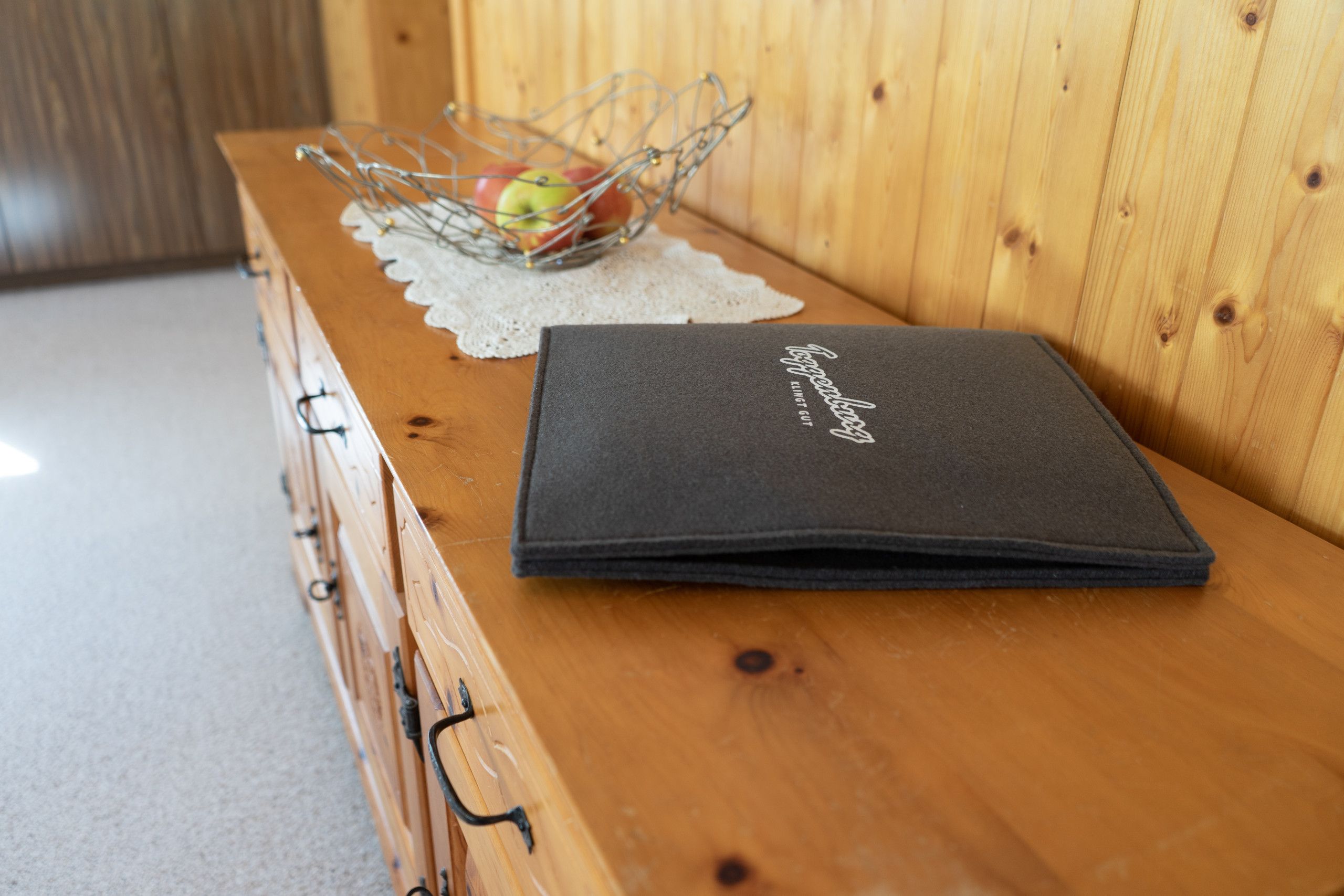 A dark grey folder with the text 'Sofitel' on a wooden table.