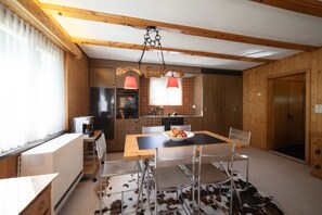 Una cocina moderna con armarios de madera, un refrigerador de acero inoxidable y una cafetera.