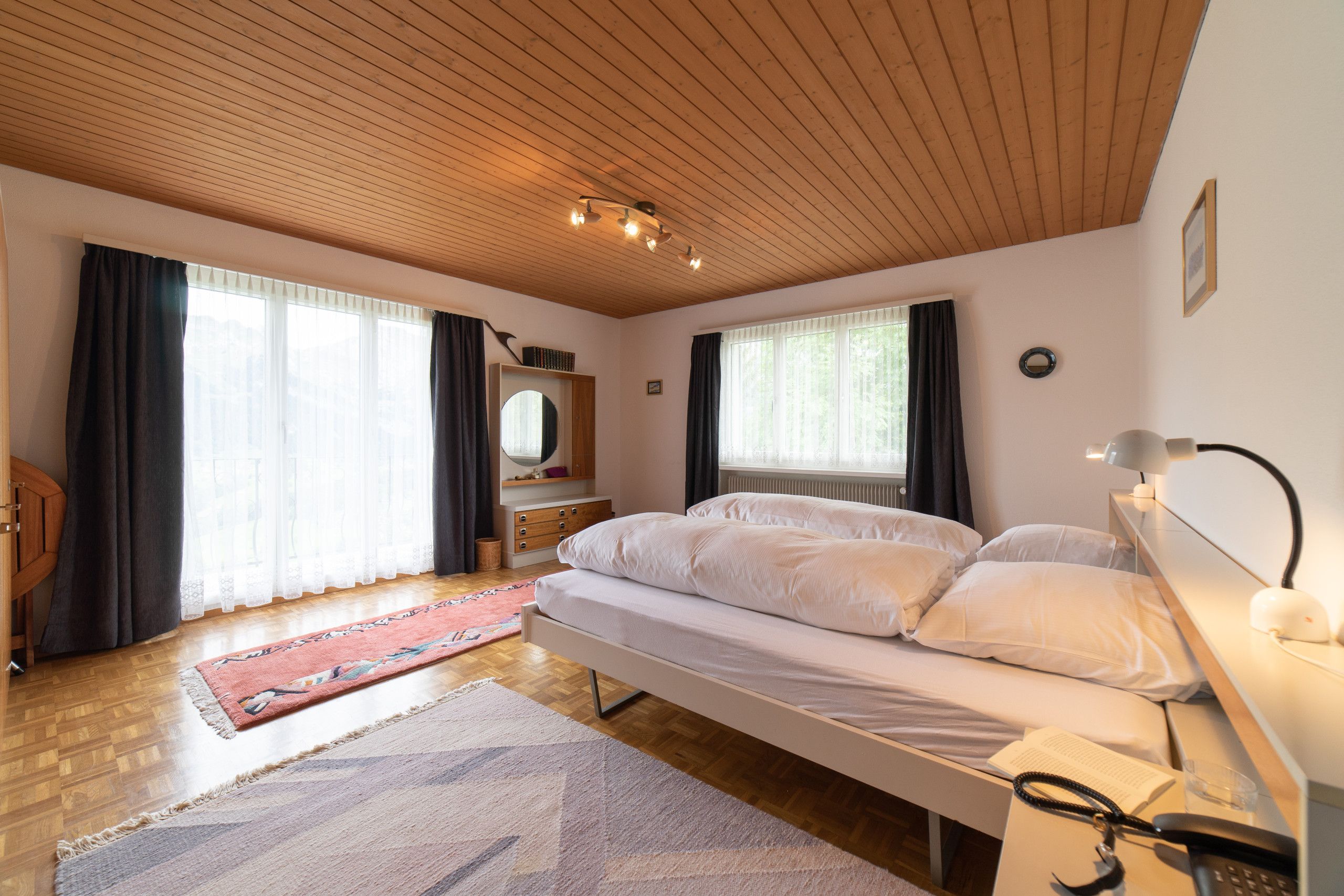 Grande chambre avec lit double et deux fenêtres
