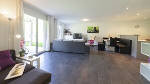 Ein modernes Wohnzimmer mit einer Couch, einem Couchtisch und einem Essbereich mit einer Bank und Tisch.
