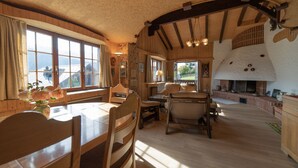 Un interior acogedor de madera con comedor, chimenea y ventanas amplias.
