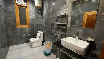 Un baño moderno con inodoro, lavamanos y ducha.
