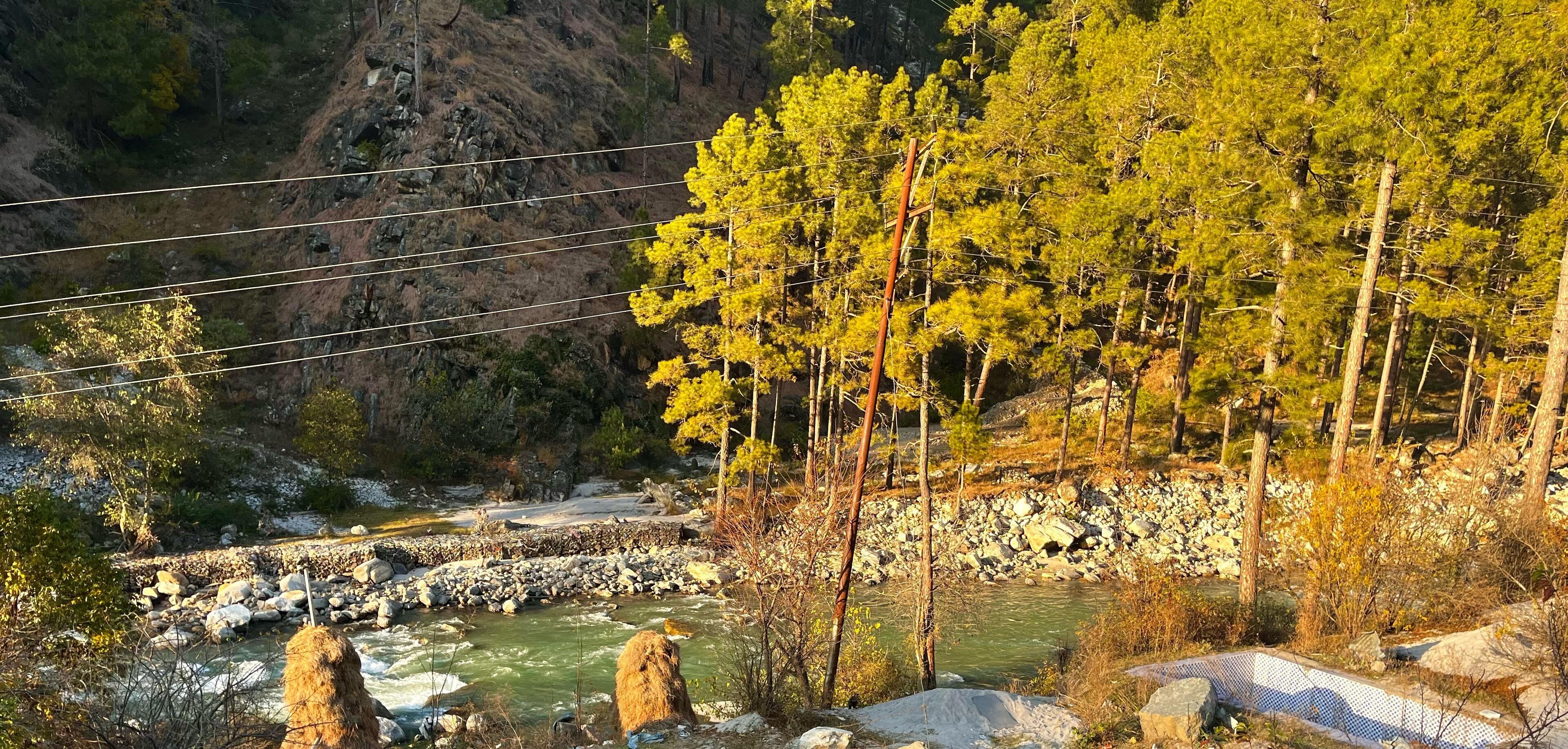 Un río con rocas y árboles en una zona montañosa.