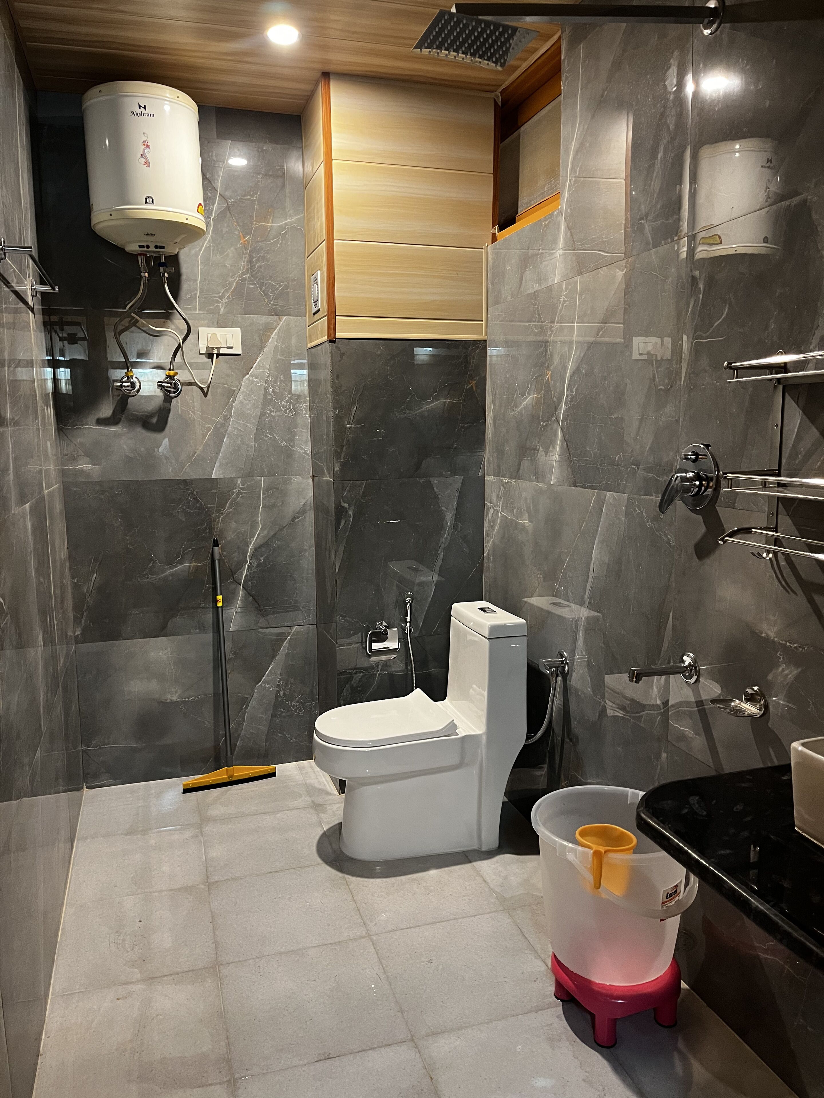 A modern bathroom with a toilet, a shower, and a sink.