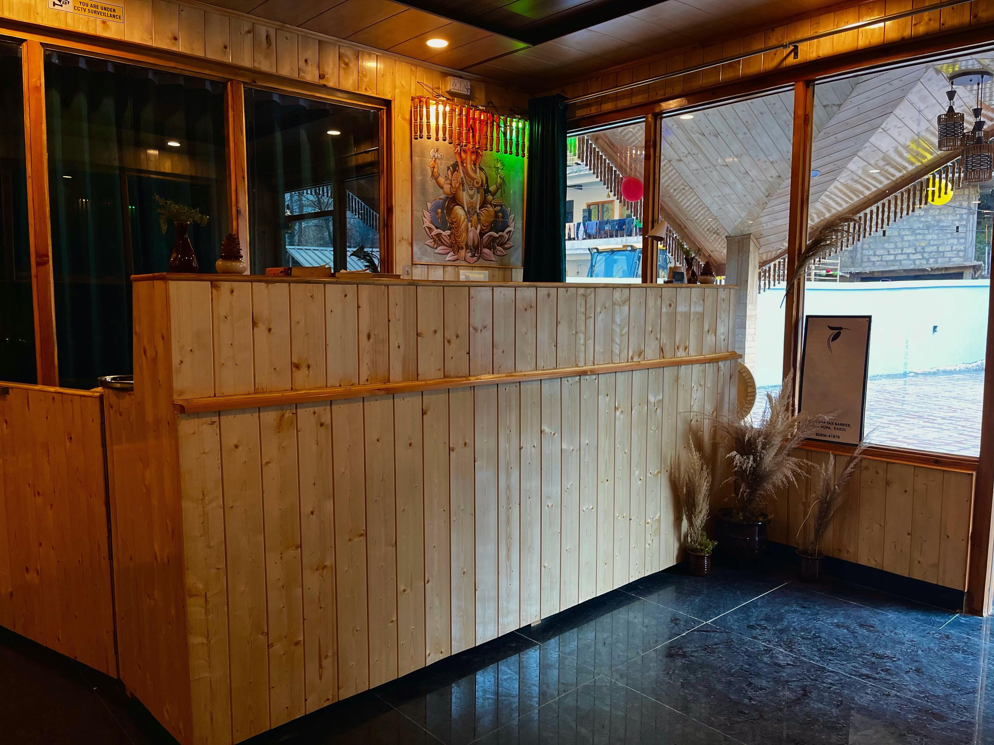 A reception area with wooden paneling, a reception desk, and a view of the outside.