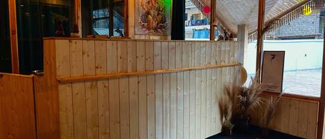 A reception area with wooden paneling, a reception desk, and a view of the outside.