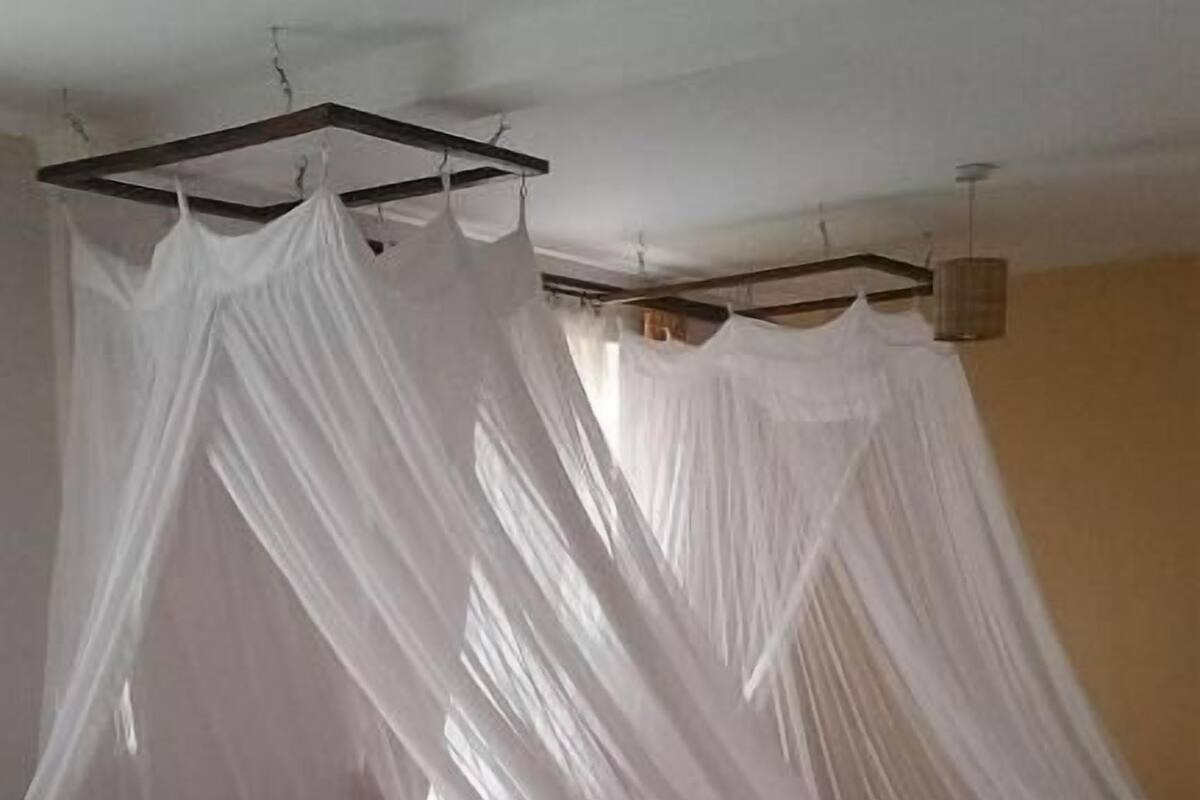 Una cama con dosel, cabecera de madera y una manta marrón.