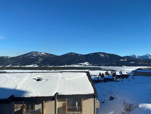 A snow-covered landscape with a mountain range in the background.