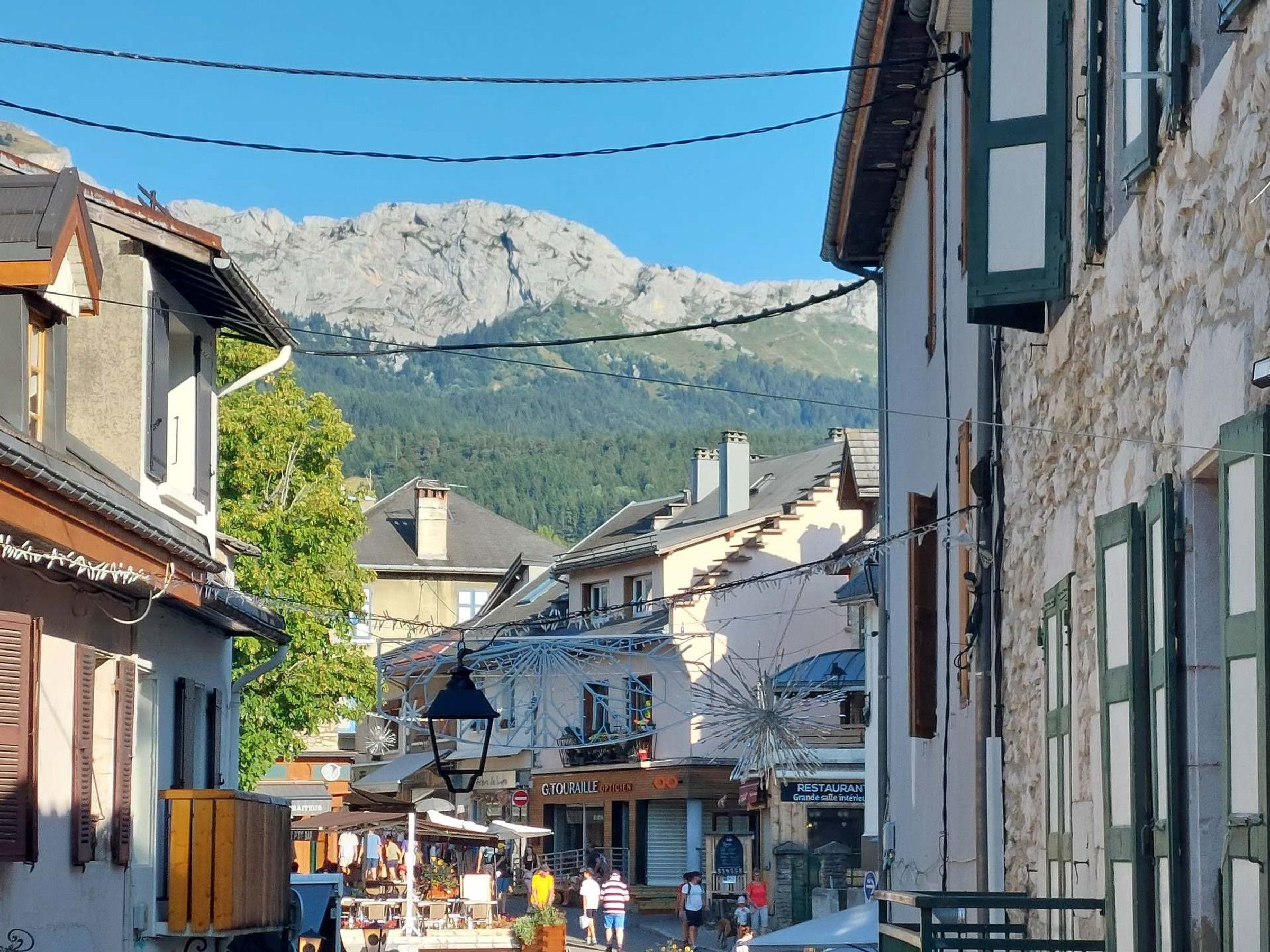 Eine Straße mit Gebäuden, einem Markt und einem Berg im Hintergrund.