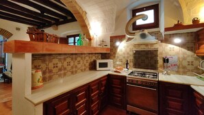 Una cocina con estufa a gas, microondas y armarios de madera.