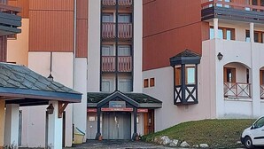 Un hotel con una torre central, varios balcones y una entrada cubierta.