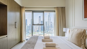 A hotel room with a large bed, a view of a cityscape, and a wooden wardrobe. - Exquisite 2BR - Breathtaking BurjSkyline (Dubai)