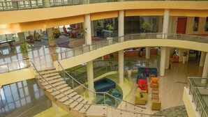 A multi-level atrium with a central spiral staircase, seating areas, and potted plants.