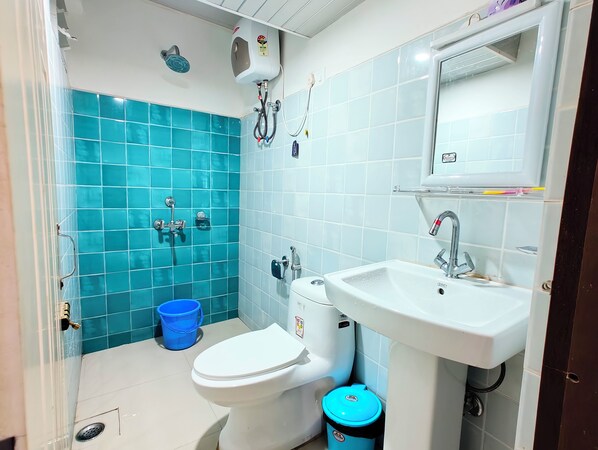 Une salle de bain avec des toilettes, un lavabo et une douche.