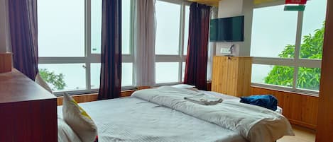 Una habitación de hotel con una cama grande, techo de madera y televisión montada en la pared.
