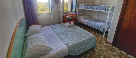 A room with a single bed, a desk, and a bunk bed.