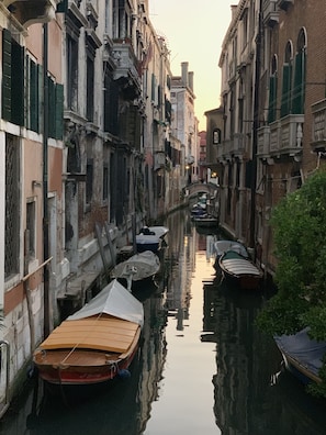 A narrow canal flanked by historic buildings with boats docked along the sides. - SUITE APARTMENT NEAR THE RIALTO MARKET   (Venezia)