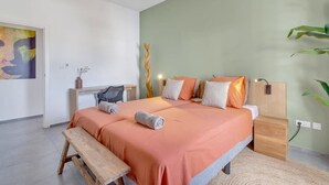 A bedroom with a bed, bedside tables, a bench, and a wall with a painting.