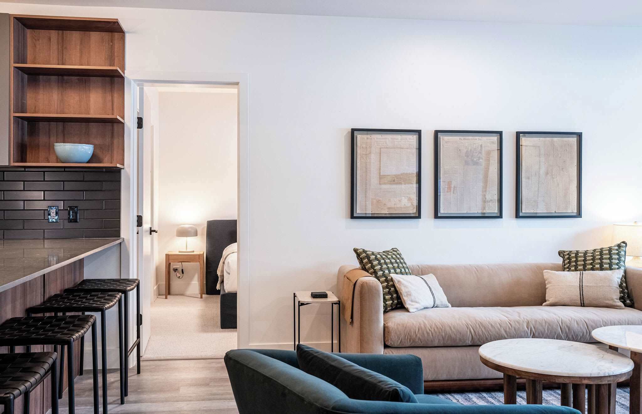 A modern living room with a sofa, a coffee table, and a bar area with stools.