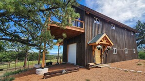 Ein rustikales Holzhaus mit Balkon, Garage und Kiesweg.