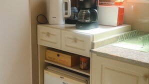 Une cuisine équipée d’une machine à café, d’un grille-pain et d’un petit réfrigérateur.