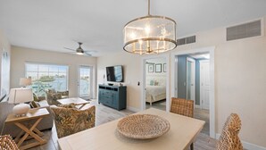 A modern living room with a dining area, a television, and a ceiling fan. - Waterfront, Harbourside, Water Park, Beach, #6615 (Indian Rocks Beach)