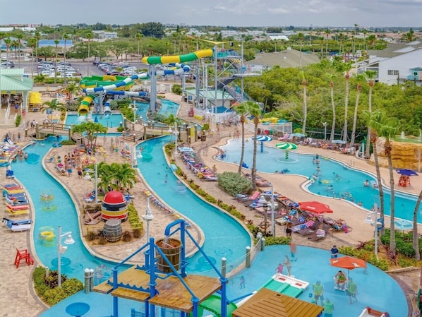Relax and play in our vibrant water park surrounded by lush greenery and palm trees.