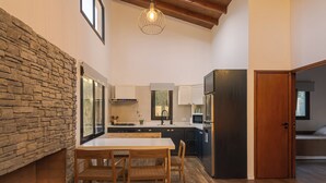 Una cocina moderna con pared de piedra, mesa de comedor de madera y sillas.