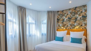 A hotel room with a large bed, a patterned wall, and sheer curtains. - Feelathome Atarazanas Apartments (Málaga)