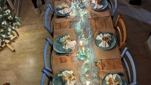 A long wooden dining table with teal plates, gold napkins, and a string of lights. - Holiday Home Le Dali in Piolenc, in Complete Tranquility (Piolenc)