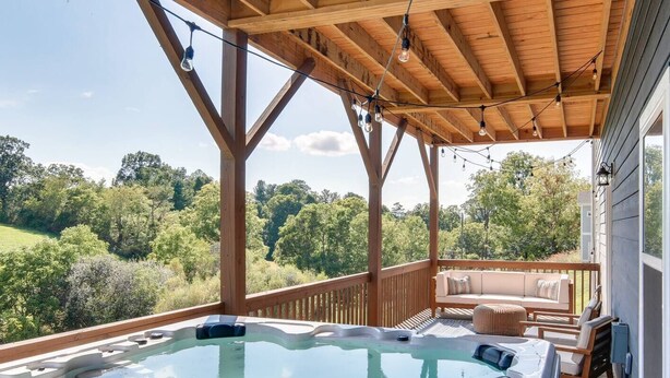 A hot tub with a wooden deck and a view of a forest. - Serene Luxury Retreat| Hot Tub|Views (Weaverville)