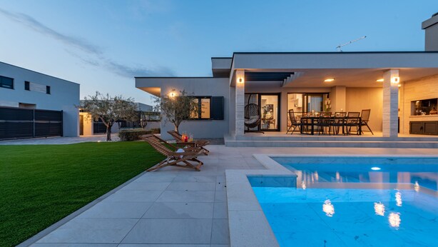 A modern house with a swimming pool, a patio with outdoor furniture, and a well-maintained lawn. - Villa Lorena Dalmacija (Nin)