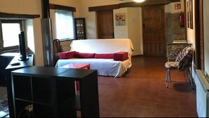 A cozy room with a bed, a fireplace, a table, and a chair. - Vivienda Vacacional Naguar Para 4 Personas en Triongo, Cangas de Onís (Triongo, Cangas de Onís)