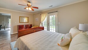 A bedroom with a bed, a ceiling fan, a dresser, a mirror, and a window with curtains. - Home w/ Private Pool - 15 Miles to Ark Encounter! (Berry)