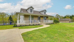 A two-story house with a covered porch, a front yard, and a driveway. - Home w/ Private Pool - 15 Miles to Ark Encounter! (Berry)
